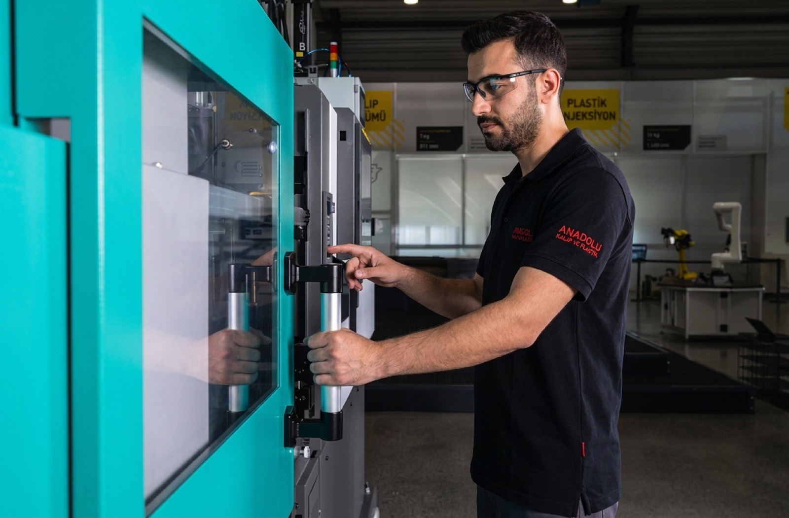 Enjeksiyon makinesinin başında çalışan operatör